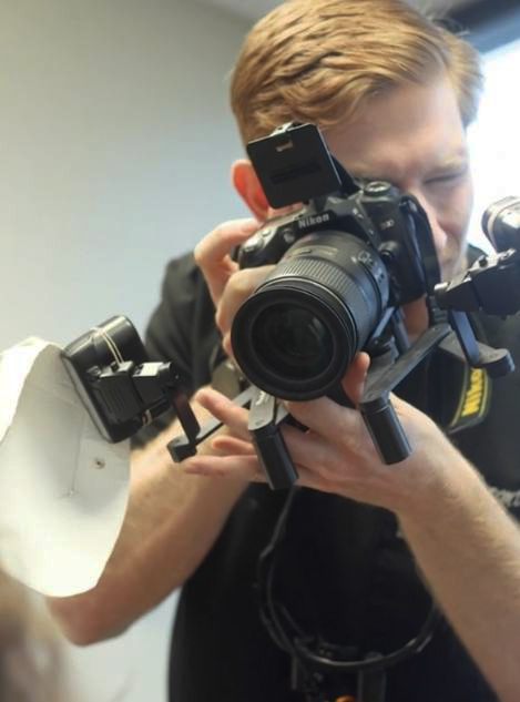 Doctor Carlisle Vason holding a camera in dental office