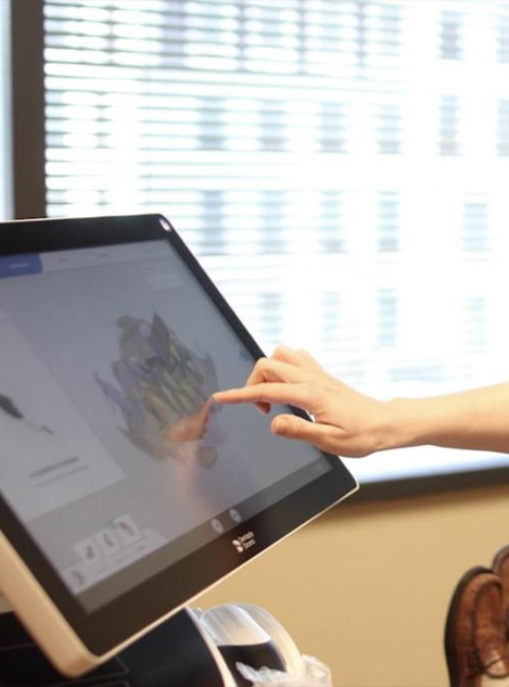 Dental team member pointing to digital images of teeth on chairside computer screen