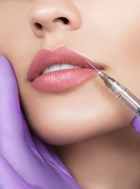 Close up of woman with needle right next to her upper lip