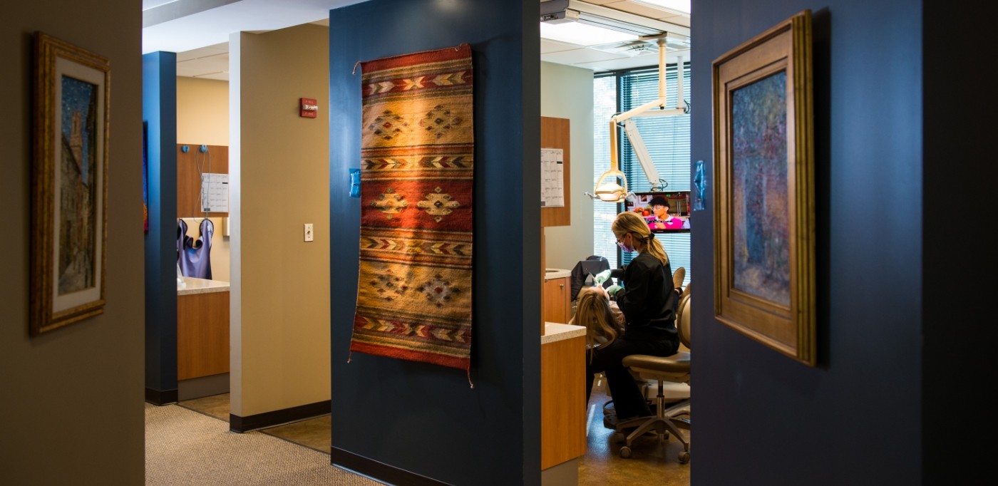 View from hallway of dental team member treating a dental patient