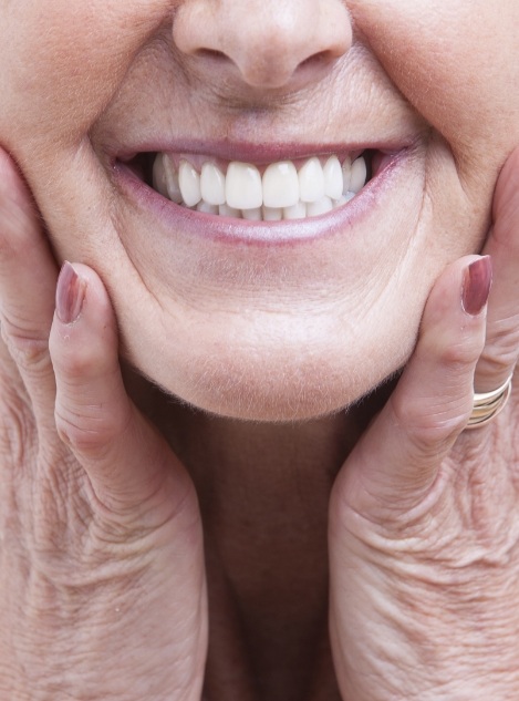 Close up of smiling senior woman touching her cheeks