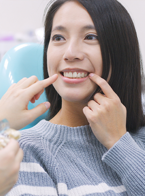 Dental patient pointing to her smile