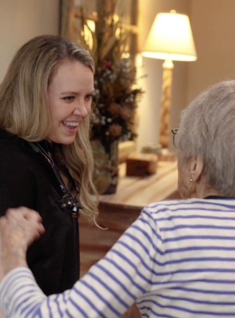 Doctor Grisham talking with an elderly female dental patient