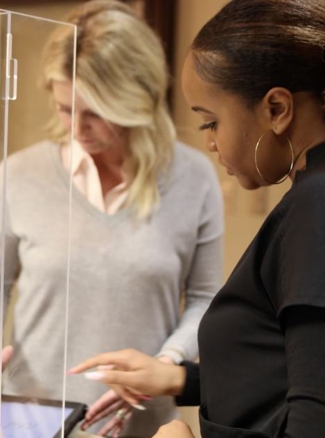 Dental team member showing a patient where to tap on tablet screen