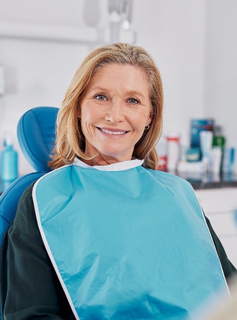 Female patient sitting in dental chair and smiling