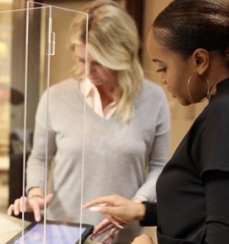 Dental patient and team member typing on tablet screen