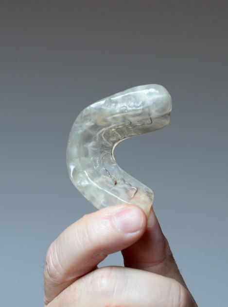 Person holding a dental nightguard in their hand