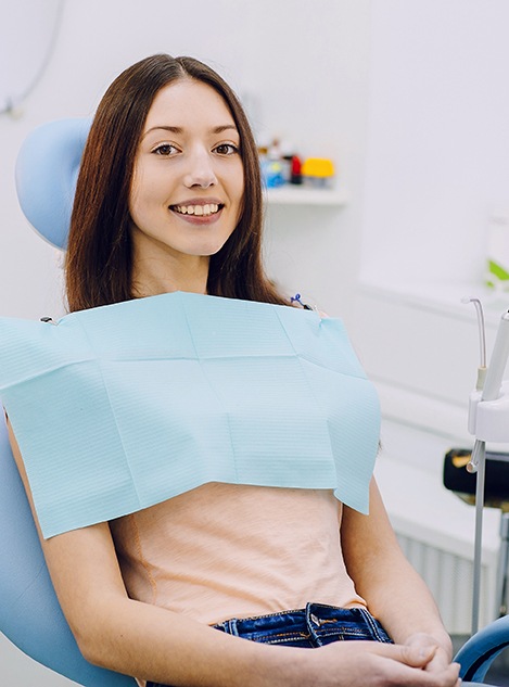 Woman sitting in dental chair smiling