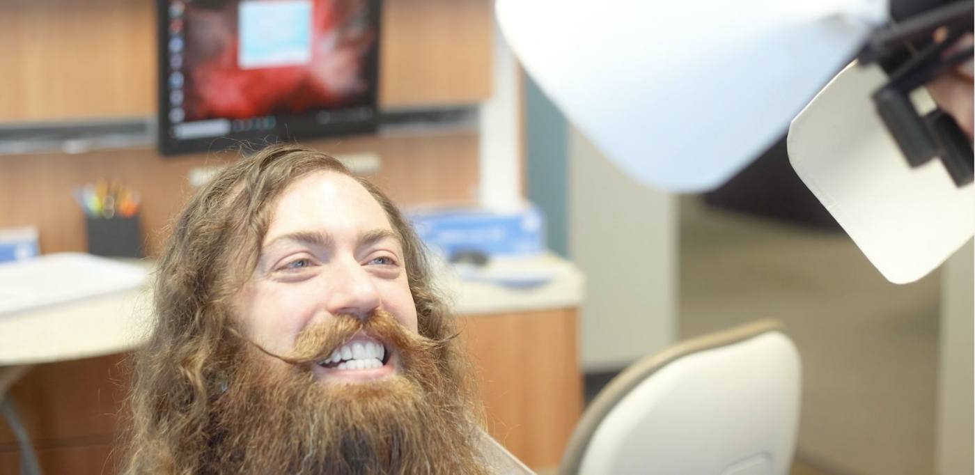 Man with long hair and beard grinning after smile makeover in Buckhead Atlanta