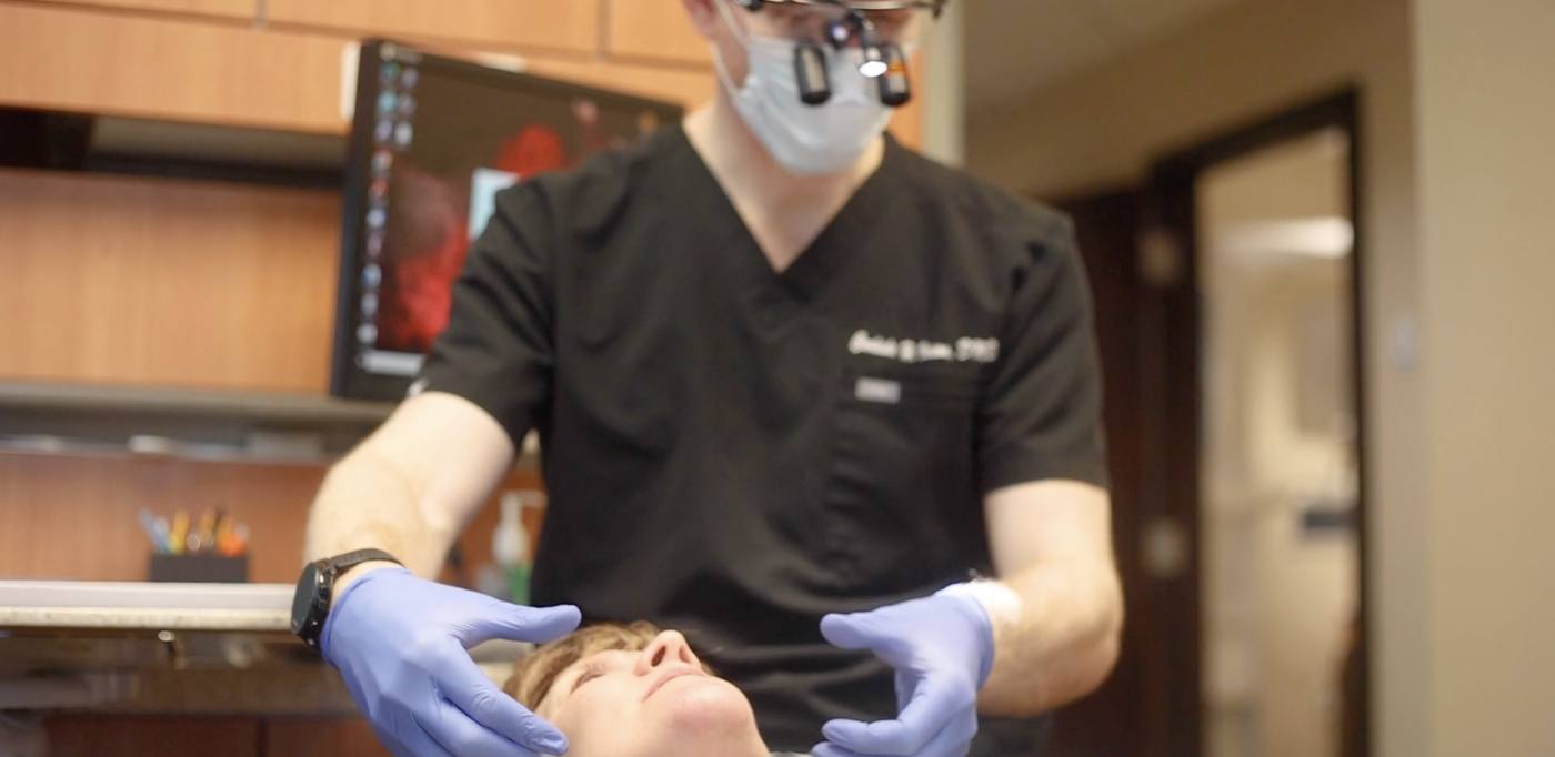 Dentist examining a patient's jaws before providing T M J treatment in Buckhead Atlanta