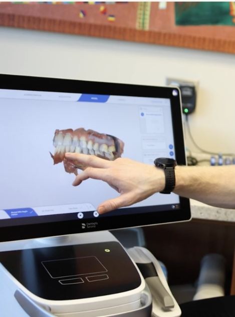 Dentist pointing to digital images of teeth on computer screen