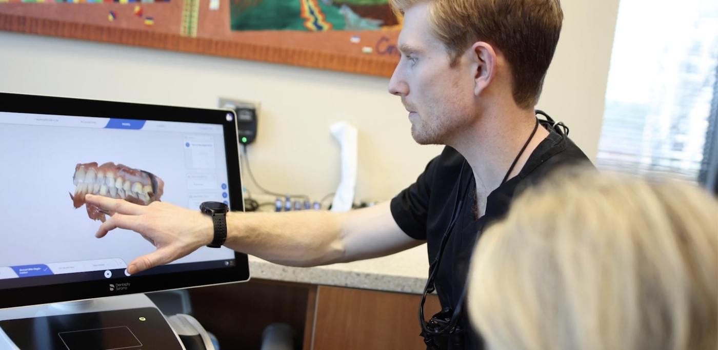 Doctor Vason showing a dental patient digital images of their teeth on computer monitor