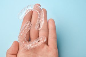 someone holding mail-in aligners in their hand
