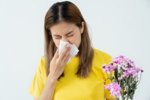 a woman blowing her nose due to April allergies