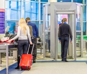 People walking through a metal detector at airport security